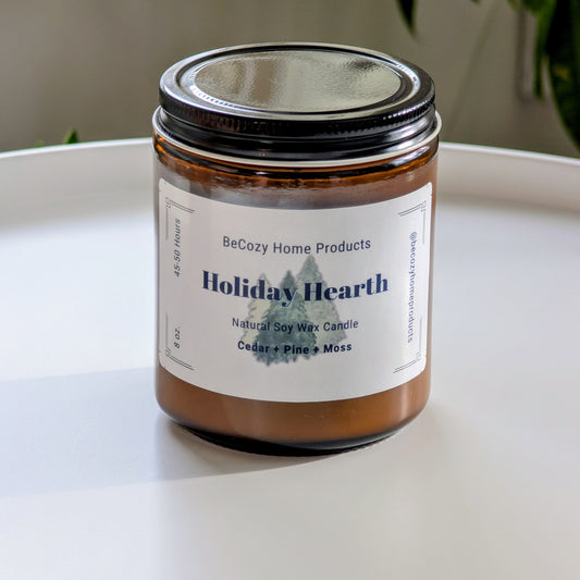Soy wax candle labeled 'Holiday Hearth' by BeCozy Home Products on a white surface.
