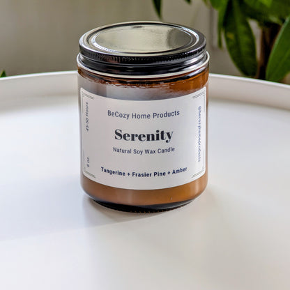 Serenity soy wax candle by BeCozy Home Products on a white surface with a plant in the background